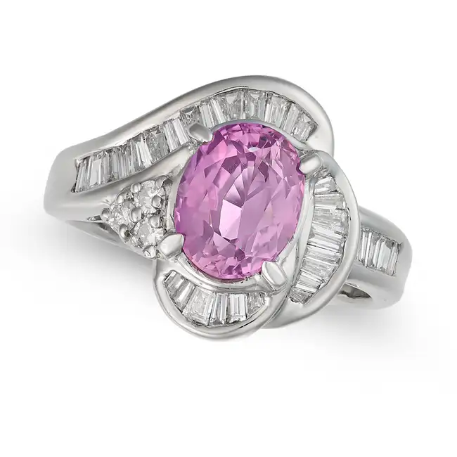 A PINK SAPPHIRE AND DIAMOND DRESS RING set with an oval cut pink sapphire of approximately 2.30
