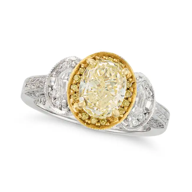 A FANCY LIGHT YELLOW DIAMOND AND DIAMOND RING in platinum, set with an oval cut yellow diamond of