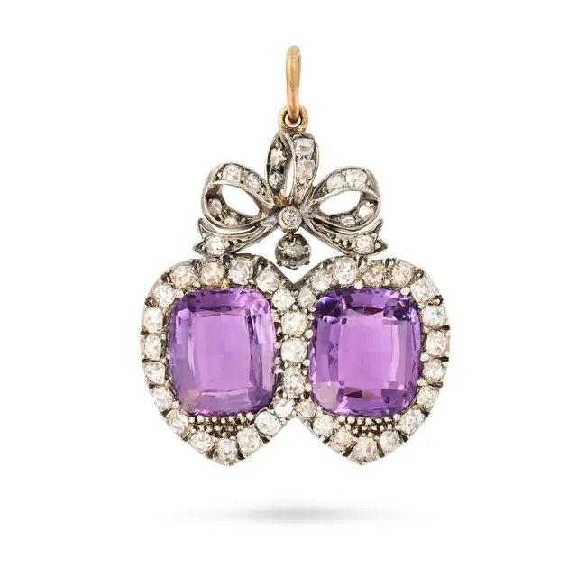 AN ANTIQUE AMETHYST AND DIAMOND SWEETHEART PENDANT in yellow gold and silver, designed as two twin