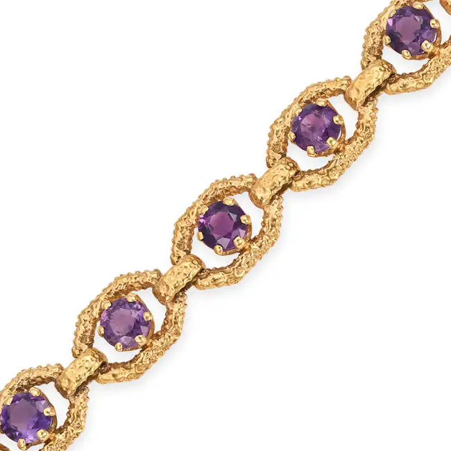 NO RESERVE - A MODERNIST AMETHYST BRACELET, 1975 in 9ct yellow gold, comprising a row of textured