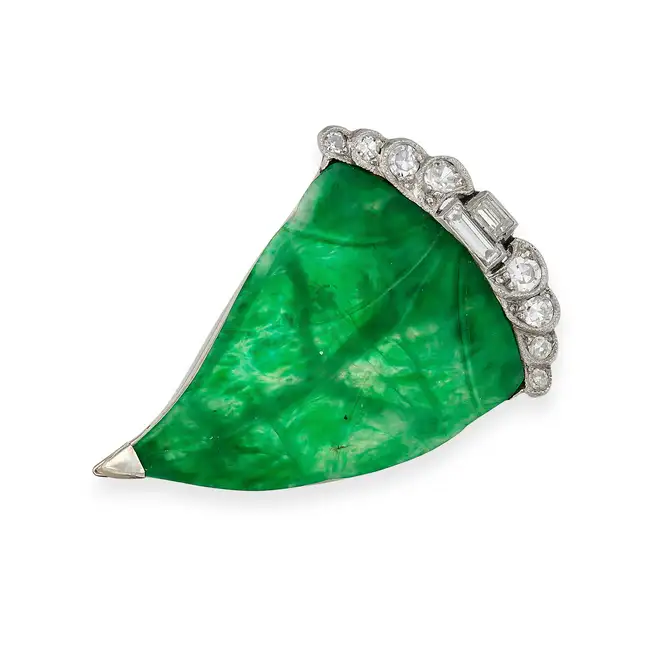 AN ART DECO JADEITE JADE AND DIAMOND LEAF CLIP BROOCH set with a polished jadeite jade plaque carved