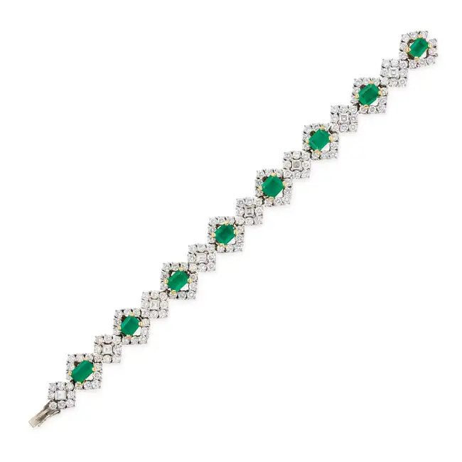 A FINE EMERALD AND DIAMOND BRACELET comprising a row of alternating octagonal step cut emeralds