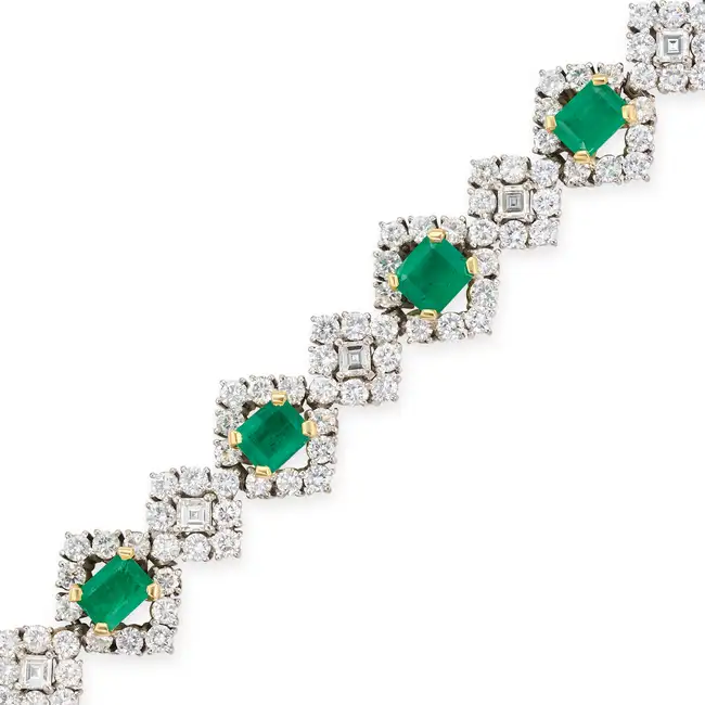 A FINE EMERALD AND DIAMOND BRACELET comprising a row of alternating octagonal step cut emeralds