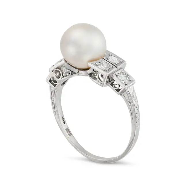 A PEARL AND DIAMOND DRESS RING set with a pearl of 9.4mm, the stepped shoulders set with round