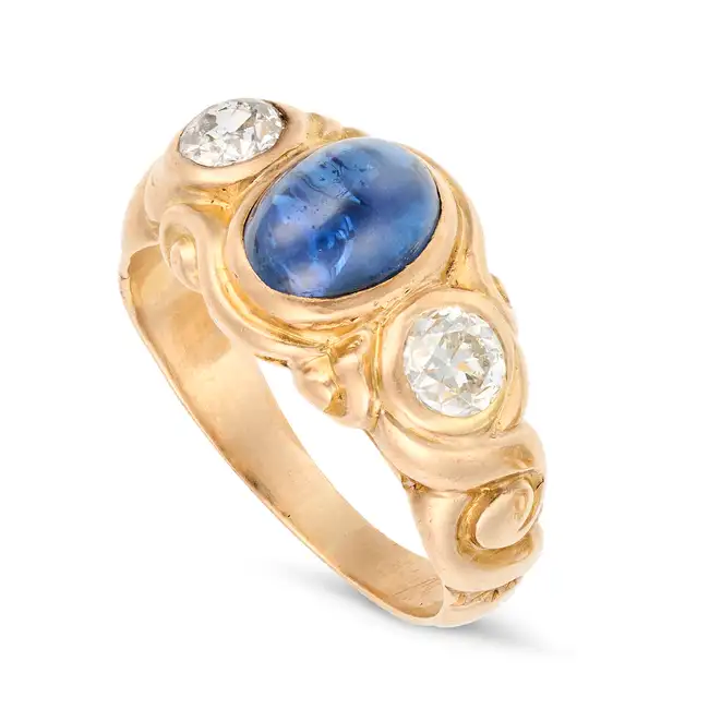 AN ANTIQUE SAPPHIRE AND DIAMOND RING in yellow gold, set with a cabochon sapphire of approximately