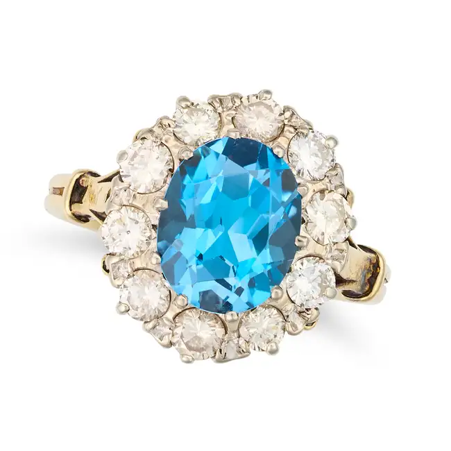 A BLUE TOPAZ AND DIAMOND CLUSTER RING set with an oval cut blue topaz in a cluster of round