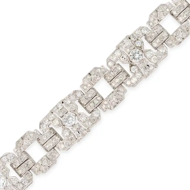 A FINE ART DECO DIAMOND STRAP BRACELET comprising a row of pierced geometric links, set throughout