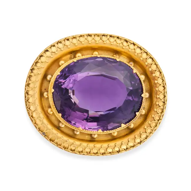 AN ANTIQUE ETRUSCAN REVIVAL AMETHYST BROOCH, 19TH CENTURY in yellow gold, set with an oval cut