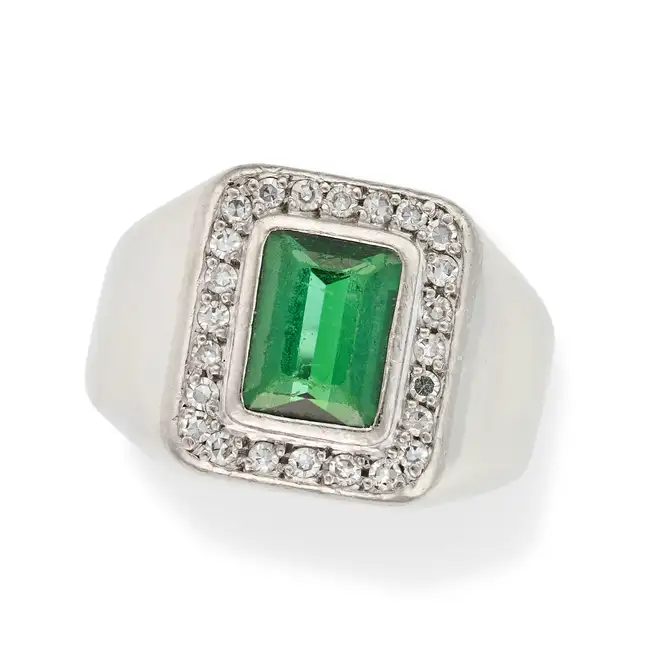 A GREEN TOURMALINE AND DIAMOND RING set with an octagonal step cut green tourmaline in a border of