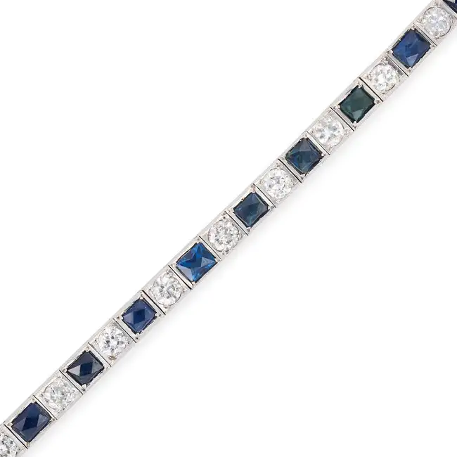 AN ART DECO SAPPHIRE AND DIAMOND LINE BRACELET comprising a row of alternating French cut