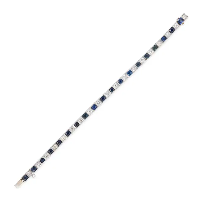 AN ART DECO SAPPHIRE AND DIAMOND LINE BRACELET comprising a row of alternating French cut
