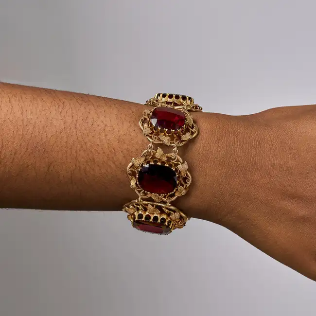 AN ANTIQUE GARNET BRACELET in yellow gold, the articulated body set with a row of graduated