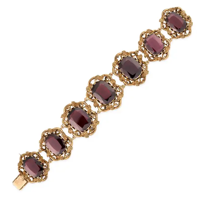 AN ANTIQUE GARNET BRACELET in yellow gold, the articulated body set with a row of graduated