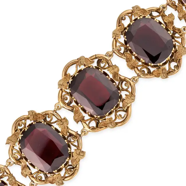AN ANTIQUE GARNET BRACELET in yellow gold, the articulated body set with a row of graduated