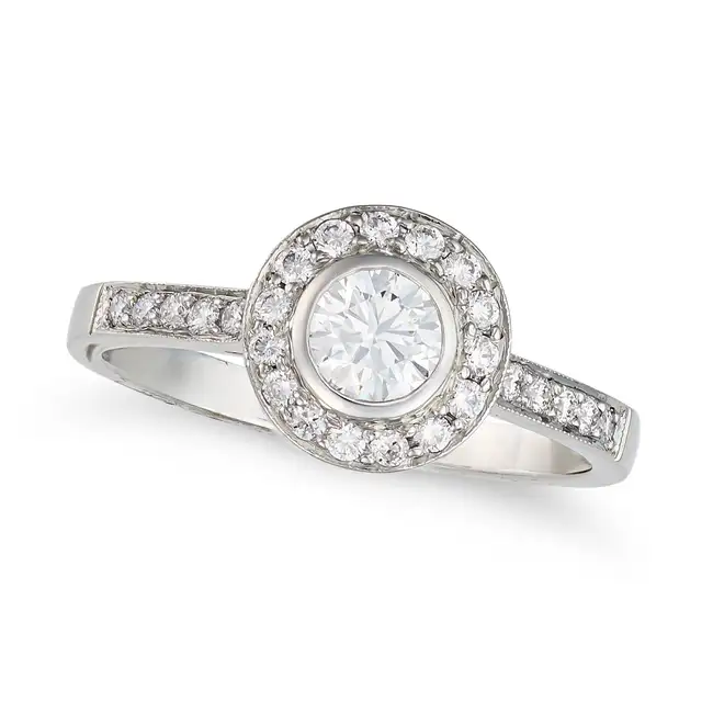 A DIAMOND HALO RING in platinum, set with a round brilliant cut diamond in a halo of round brilliant