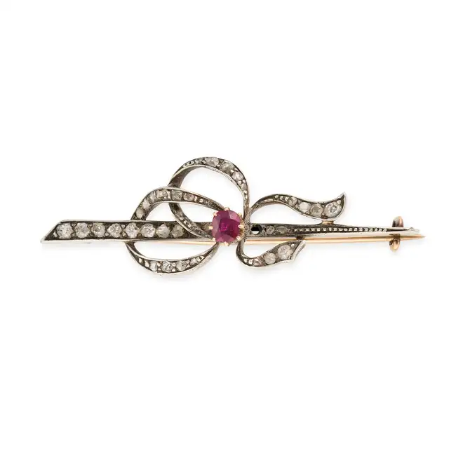 NO RESERVE - AN ANTIQUE RUBY AND DIAMOND BOW BROOCH in yellow gold and silver, designed as a bow set