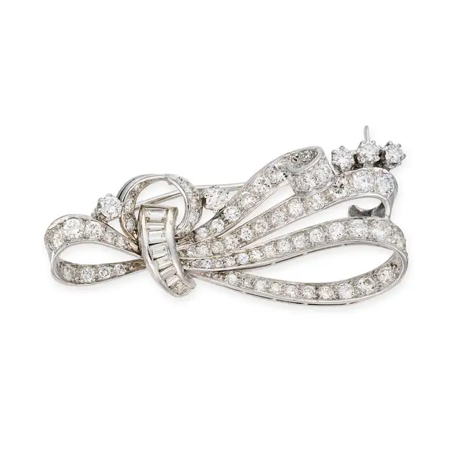 A VINTAGE DIAMOND SCROLL BROOCH the brooch designed as a scrolling ribbon set with round brilliant