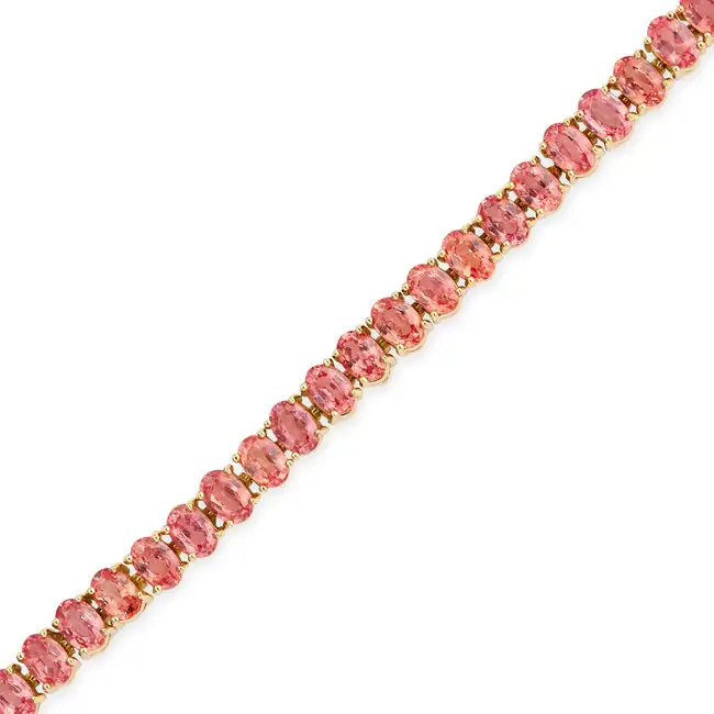 A PEACH SAPPHIRE LINE BRACELET comprising a row of oval cut peach sapphires totalling 17.5-18.0
