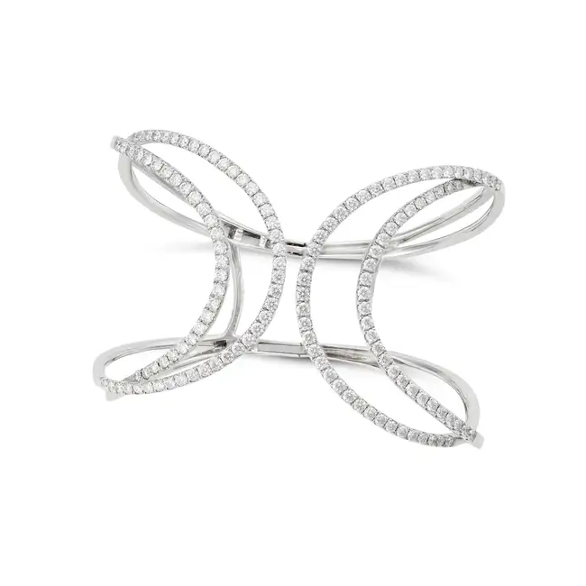 A DIAMOND CUFF BANGLE in 18ct white gold, the stylised hinged bangle terminating at each end with