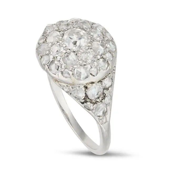 A DIAMOND CLUSTER RING set with a cluster of old and rose cut diamonds, the shoulders set with