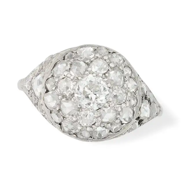 A DIAMOND CLUSTER RING set with a cluster of old and rose cut diamonds, the shoulders set with
