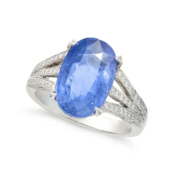 A SAPPHIRE AND DIAMOND DRESS RING in platinum, set with an oval cut sapphire of approximately 4.02
