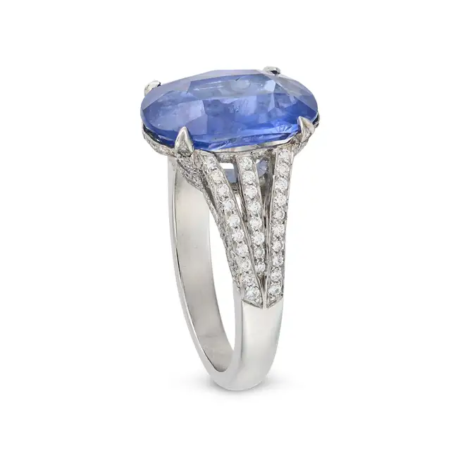 A SAPPHIRE AND DIAMOND DRESS RING in platinum, set with an oval cut sapphire of approximately 4.02
