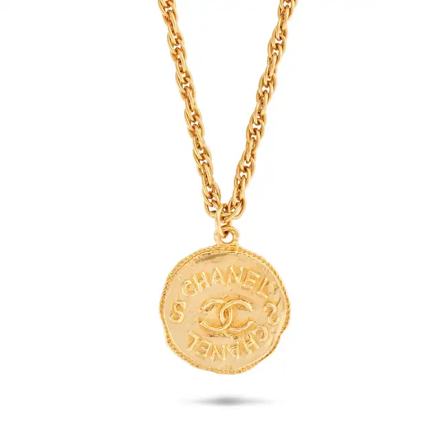 CHANEL, A CC MEDALLION PENDANT NECKLACE comprising a fancy link chain with a circular medallion