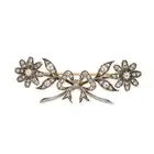AN ANTIQUE DIAMOND BROOCH in yellow gold and silver, comprising a bow motif accented by two flowers,
