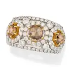 A FANCY COLOUR DIAMOND DRESS RING set with three rose cut diamonds totalling 1.36 carats, accented
