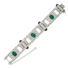 A FINE ART DECO EMERALD, DIAMOND AND ONYX STRAP BRACELET comprising a row of geometric motifs with