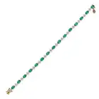AN EMERALD AND DIAMOND BRACELET in 18ct yellow gold, comprising a row of oval cut emeralds, accented
