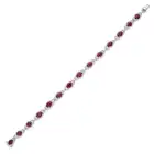 OSCAR FRIEDMAN, A RUBY AND DIAMOND BRACELET set with a row of oval cut rubies in borders of round