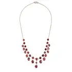 A GARNET FRINGE NECKLACE comprising a trace chain set with a row of round cut garnets, suspending