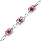 A RUBY AND DIAMOND BRACELET comprising a row of fancy links, set with oval cut rubies accented by