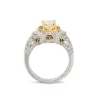 A FANCY LIGHT YELLOW DIAMOND AND DIAMOND RING in platinum, set with an oval cut yellow diamond of