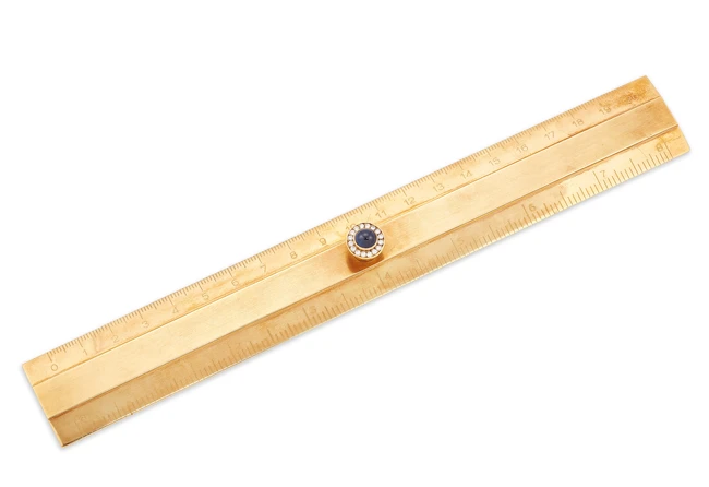 A ruler, the handle set with a cabochon sapphire and brilliant-cut diamond cluster, stamped 750,...