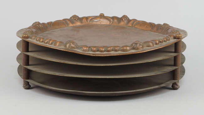 
	
		A Continental copper Sader tray, 19th century, circular with four tiers, raised scroll...