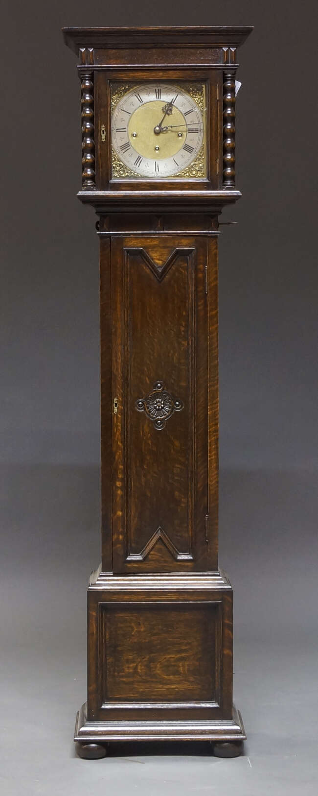 
	
		An Edwardian oak grandmother clock, early 20th century, with plain case, the brass dial...