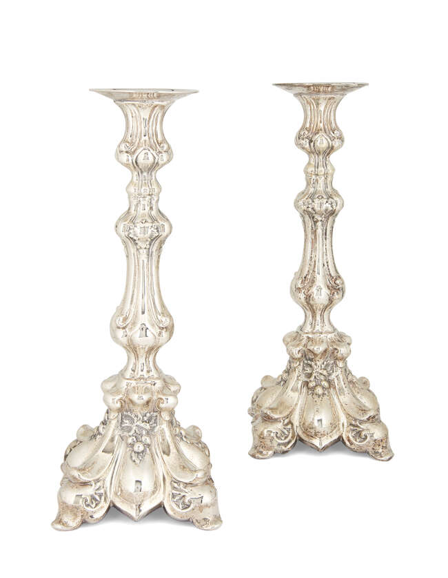 
	
		A pair of continental white metal candlesticks, stamped 900, of shaped baluster form, the...