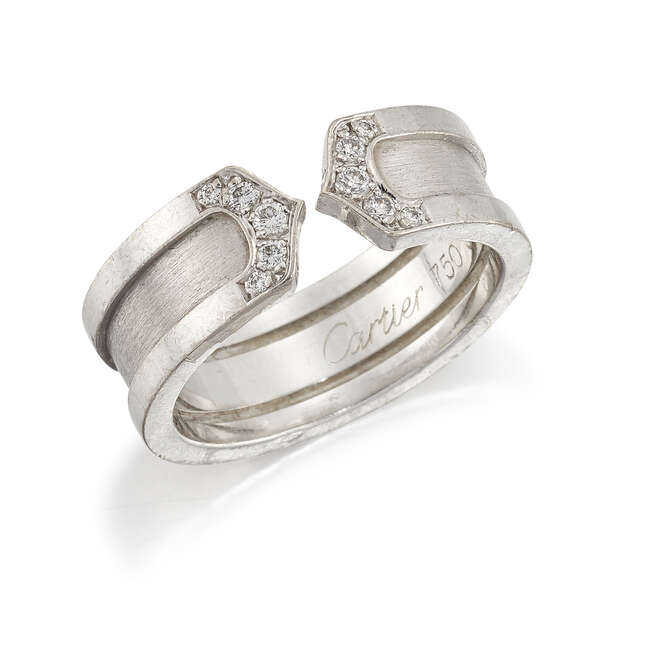 
	
		A diamond ring by Cartier, the wide brushed metal band to pave diamond chevron points...