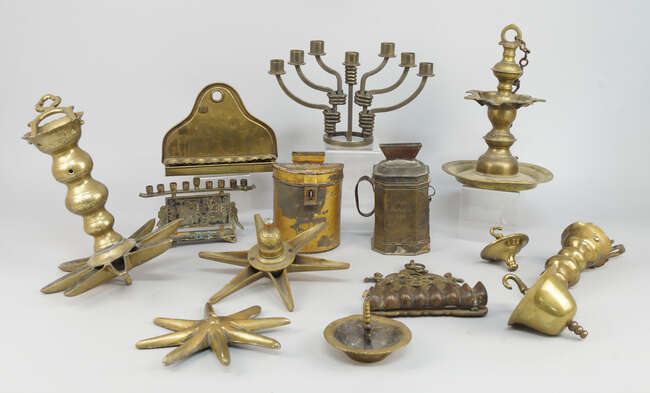 
	
		A group of brass Judaica, comprising two charity boxes, one with Hebrew inscription to...