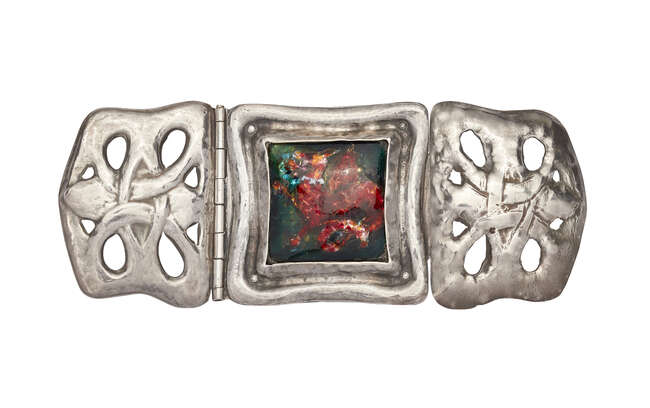 
	
		An Arts and Crafts silver-coloured metal and foil-backed enamel buckle
		c.1900
		In...
