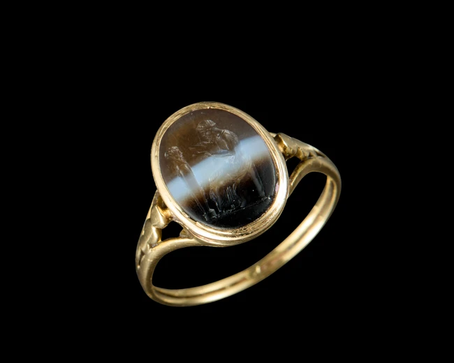 A Roman banded agate intaglio of a man seated at herm set in an antique gold ringcirca 1st...