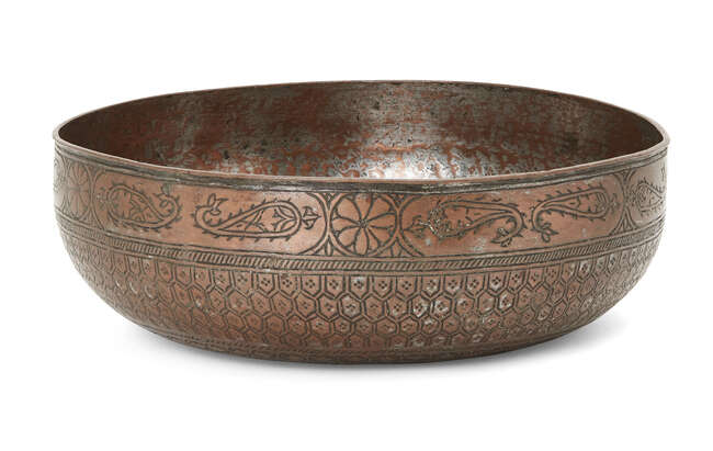 An engraved tinned copper magic bowl,North India, 19th century,
On plain base, densely inscribed...