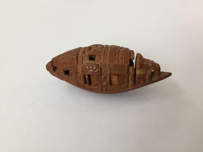 
	
		A Chinese hediao nut and stand, early 20th century, carved as a boat and inscribed to the...