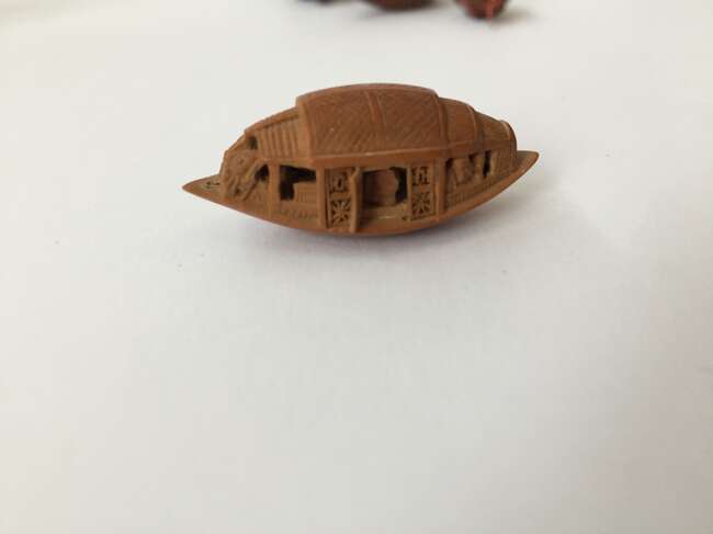 
	
		A Chinese hediao nut and stand, early 20th century, carved as a boat and inscribed to the...