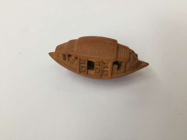 
	
		A Chinese hediao nut and stand, early 20th century, carved as a boat and inscribed to the...