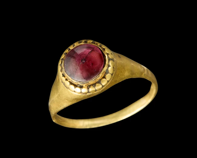 A gold ring set with garnet,Possibly Byzantine,The band plain, the stone in circular mount with...