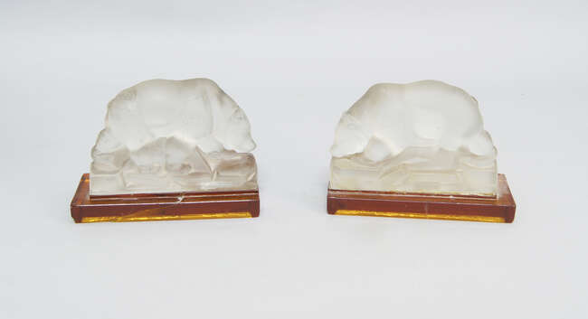 
	
		A pair of frosted glass bears, 20th century, moulded on rocky bases, with amber glass...